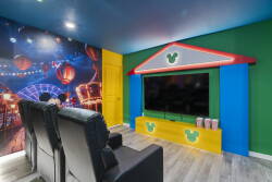 Welcome to our vibrant entertainment room, adorned with a playful carnival mural and colorful walls. Relax in plush leather seating for movie nights, with a sleek TV setup perfect for creating memorable family fun.