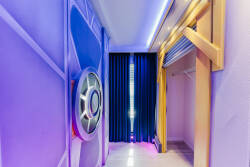 Enter a lively corridor with vibrant purple walls bathed in ambient light, setting a playful mood. You'll find a stunning wall feature and modern closet doors that give this area its distinctive charm.