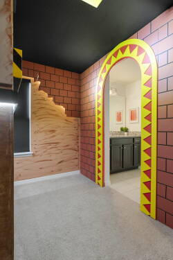 Step into a uniquely designed entryway where bold, colorful patterns meet sleek cabinetry. The textured walls create a playful atmosphere, while the natural light highlights the inviting space, setting the tone for your stay.