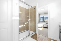 Experience a beautifully designed bathroom with a sleek glass shower that fills the space with natural light. The warm tile tones and modern fixtures create a fresh, clean atmosphere ideal for your daily routines.