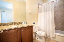 Welcome to a bright bathroom with a chic granite countertop that exudes sophistication. The neutral tile tones and warm wood cabinetry create a relaxing atmosphere, ideal for unwinding after a day of adventures.