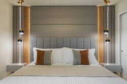 Enjoy restful nights in our beautifully styled bedroom with a plush tufted headboard, warm wooden accents, and elegant pendant lights. Cozy throw pillows invite you to unwind and recharge for the day ahead.