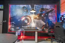 Experience a lively entertainment room adorned with a stunning superhero mural that brings energy to the space. The modern table and bright accents set the stage for unforgettable game nights or movie marathons.