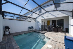 Step into your own oasis with a shimmering pool framed by sleek tiles and a spacious deck. Enjoy the sunshine under the protective screen while relaxing on comfortable outdoor seating, perfect for leisurely afternoons.