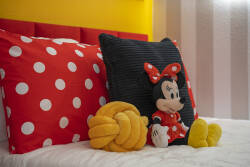 Brighten your stay with this playful bedroom featuring vibrant yellow walls and cheerful polka dot pillows. A cozy Minnie Mouse plush adds a whimsical touch, inviting you to relax in a uniquely charming atmosphere.