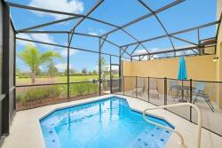 Step into your own private oasis featuring a sparkling pool surrounded by a sleek, screened enclosure. The inviting blue water reflects the sunny sky, while a cozy seating area awaits, perfect for relaxing after a refreshing swim.