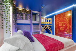 Let kids dream in a Snow White inspired bedroom with cozy bunk beds, bright blue walls, storybook décor, greenery, soft lighting, and a playful loft design that brings a fairytale feel to bedtime.