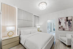 Enjoy a beautifully designed bedroom with a plush king-sized bed and calming neutral tones that promote tranquility. The stylish light fixture and modern artwork enhance the sophistication, making it the perfect retreat to unwind.
