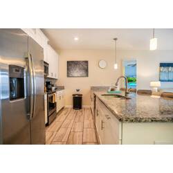 Discover a stylish kitchen with granite countertops and stainless steel appliances, ideal for culinary adventures. The warm lighting and modern decor create a welcoming atmosphere, making it the perfect place to start your day.