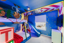 Welcome to a whimsical children's room with vibrant blue walls, playful decor, a fun slide, and a colorful bunk bed. Natural light fills this imaginative space, inspiring creativity and adventure for your little ones.