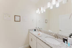 Experience this beautifully designed bathroom with a sleek granite countertop that combines style and practicality. Bright overhead lighting creates an airy atmosphere, and framed art adds a personal touch to your daily routine.