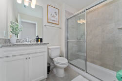 Enjoy the comfort of this elegant bathroom with granite countertops and a spacious glass-enclosed shower. The soothing neutral tones create a relaxing atmosphere, ideal for unwinding after your day's adventures.