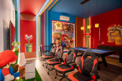 Welcome to our vibrant game room, filled with playful colors and bold artwork that energizes the space. Enjoy sleek gaming chairs, a stylish pool table, and flickering LED lights, perfect for fun evenings with friends and family.