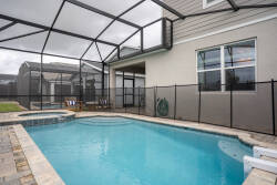 Step outside to discover your private oasis featuring a sparkling pool and stylish screened enclosure. The elegant stone patio invites relaxation, and comfy lounge chairs are perfect for sun-soaked afternoons and serene evenings.