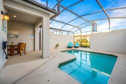 Step into your own private oasis, where a tranquil pool invites you to unwind. The airy space is complemented by modern lounge chairs and a cozy dining set, perfect for enjoying the sunshine under the expansive blue sky.