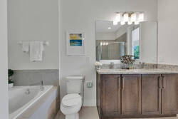Refresh in a bright bathroom with a soaking tub, granite vanity, large mirror, soft towels, modern lighting, and neutral finishes, creating a clean and comfortable space.