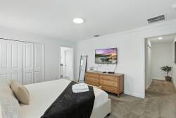 Enjoy restful nights in this thoughtfully designed bedroom, featuring a cozy bed with plush linens and a warm palette. Ample storage in the stylish wooden dresser, soft lighting, and a flat-screen TV ensure a relaxing stay.