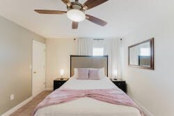 Experience a cozy bedroom with soothing beige and light purple tones. Enjoy the stylish ceiling fan and modern lighting that enhance the chic decor, while the plush bedding beckons you to relax after a day of exploring.