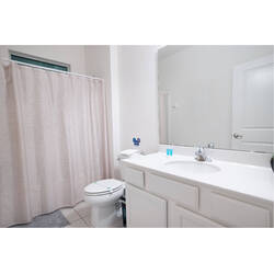 Refresh in a clean and bright bathroom with a spacious vanity, large mirror, shower and tub combo, and soft neutral tones. Simple finishes, good lighting, and practical amenities create a comfortable space for your vacation.