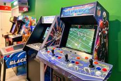 Enjoy a fun game room corner with arcade machines, colorful controls, a wall-mounted TV, bright green walls, and playful decor, creating a great space for family entertainment during vacation.