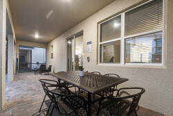 Enjoy al fresco dining on our spacious patio, featuring a chic metal table and cozy chairs. The warm stone flooring enhances the inviting atmosphere, creating a perfect spot for you to relax and unwind.