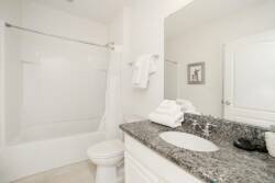 Step into this clean and bright bathroom, featuring a sleek granite countertop paired with soft, fluffy towels. The light color palette enhances the airy feel, while the spacious tub invites you to unwind after a day of adventure.