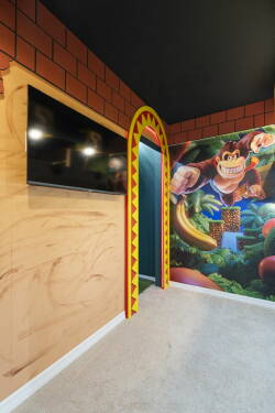 Enter a playful space filled with vibrant murals and a whimsical character that sparks nostalgia. The unique archway and warm wood tones create a welcoming atmosphere, ideal for both relaxation and enjoyment.
