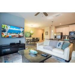 Welcome to a stylish living area featuring a plush white sofa perfect for relaxation, a chic coffee table, and vibrant artwork. The open layout connects this inviting space to a modern kitchen for ultimate comfort and style.