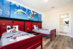 Kids will adore this vibrant bedroom with playful red beds and cheerful Mickey and Minnie Mouse bedding. The bright wall mural and natural light create a fun, welcoming atmosphere perfect for young guests.
