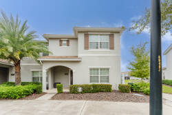 Welcome to this charming vacation home, where a light exterior meets lush greenery and palm trees. As you enter through the classic archway, you'll discover the warmth and comfort that awaits you inside.