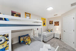 This cheerful Minions-themed bedroom features vibrant wall art and cozy bedding, creating a fun and relaxing space. With a sturdy bunk bed and a separate twin bed, it offers flexible sleeping arrangements for kids or extra guests.