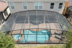 Step outside to your private oasis with a sparkling pool and a spacious screened patio. Relax on stylish loungers amidst lush greenery and enjoy the serene ambiance created by the natural light filtering through.