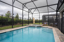Enjoy your private oasis featuring a beautiful pool with sparkling blue waters and elegant stone pavers. The spacious screened enclosure is perfect for relaxing afternoons, blending indoor comfort with outdoor enjoyment.