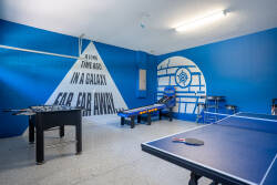 Enter our vibrant game room with rich blue walls and playful murals, perfect for friendly competition. Enjoy foosball or table tennis in a lively atmosphere, all while relaxing in comfortable seating.