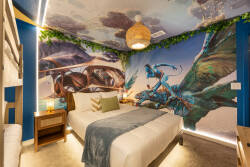 Enjoy a unique sleep experience with a stunning mural that transports you, paired with a cozy plush bed and soothing lighting. The vibrant colors and natural textures create a playful yet relaxing ambiance for your stay.