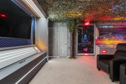 Enjoy a unique ambiance with a colorful, textured ceiling and stylish lighting. Relax in plush seating while watching your favorite shows on a sleek TV, creating the perfect spot to unwind and feel at home.