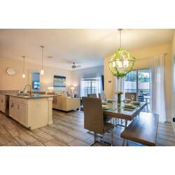 Enjoy meals in this bright and airy dining area, featuring a stylish glass table and contemporary chairs. Elegant pendant lighting creates a warm ambiance, and large windows bring in natural light and beautiful views.