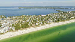 Discover a stunning coastal view, where the turquoise waters meet sandy shores, framed by charming beach homes. This vibrant landscape invites you to explore the local charm, providing a picturesque backdrop for your getaway.
