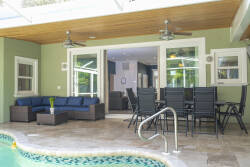 Step into this airy outdoor lounge, where a deep blue sectional invites relaxation beside the glistening pool. Natural light floods in, highlighting the sleek dining set and inviting you to enjoy meals in a refreshing atmosphere.