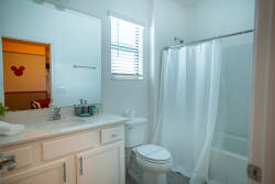 Bright and airy, this bathroom features a clean white palette complemented by a sleek vanity and modern fixtures. The natural light streaming through the window enhances the space, making it perfect for refreshing mornings.