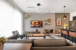 Enjoy a beautifully designed living area where modern style meets comfort. The patterned accent wall and sleek light fixtures welcome you, while plush seating and a wood coffee table offer a warm space for relaxation or.