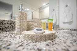 Start your day refreshed in this beautifully designed bathroom with a sleek granite countertop and stylish accessories. It combines charm and functionality, inviting you to relax and indulge in a little pampering.