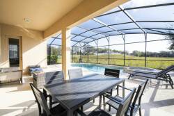 Step outside to savor al fresco dining at a sleek outdoor table, surrounded by a screened patio with stunning views. Relax by the inviting pool, ideal for soaking up the sun in a peaceful atmosphere.