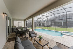 Relax in our inviting outdoor lounge with sleek gray seating by the sparkling pool. Enjoy alfresco dining in a spacious layout, where natural light flows through the screened enclosure, creating a refreshing and serene atmosphere.