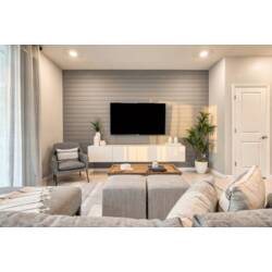 Relax in the airy living room, where soft gray tones harmonize with natural textures. A sleek, white media console and tasteful greenery complement the light-filled space, inviting you to unwind after a day of adventure.