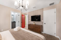 Relax in a cozy bedroom with plush brown bedding after your day's adventures. The stylish wood dresser and soft wall tones create a calming atmosphere, while the unique red door adds a welcoming pop of color to the space.