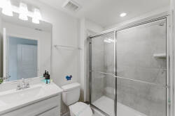 Bright and clean, this bathroom features a sleek glass shower and a stylish vanity with ample counter space, perfect for your morning routine. The neutral tones create a fresh atmosphere, making it a pleasant start to your day.