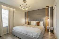 Experience serene nights in our beautifully designed bedroom with a plush king-sized bed, cozy pillows, and stylish lighting. The soft tones and natural light from the large window provide a calming atmosphere for your stay.