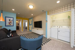 Bright colors frame this cozy living room, where a plush black sofa invites relaxation. The playful wall art adds character, while a chic black and white rug anchors the space, creating a lively atmosphere for your stay.