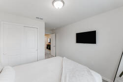 This cozy bedroom features a plush bed with soft linens for your relaxation after a day of exploration. A sleek wall-mounted TV provides entertainment, while the minimalist decor enhances the tranquil atmosphere for your stay.